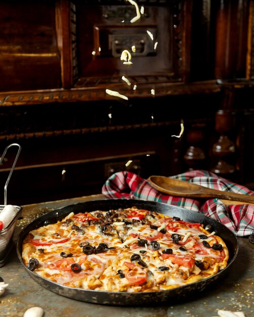 Pizza mixta con carne y chicek, tomate y queso.