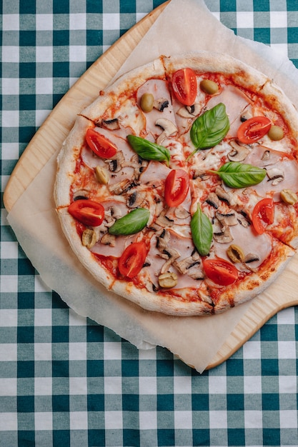 Pizza napolitana con champiñones, queso, rúcula, albahaca, tomates espolvoreados con queso