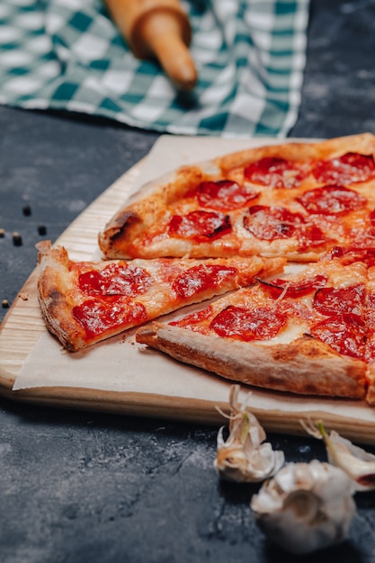 Pizza napolitana deliciosa en una pizarra con varios ingredientes, espacio libre para texto