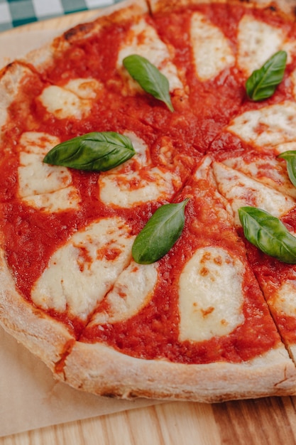 Foto gratuita pizza napolitana con jamón, queso, rúcula, albahaca, tomates espolvoreados con queso