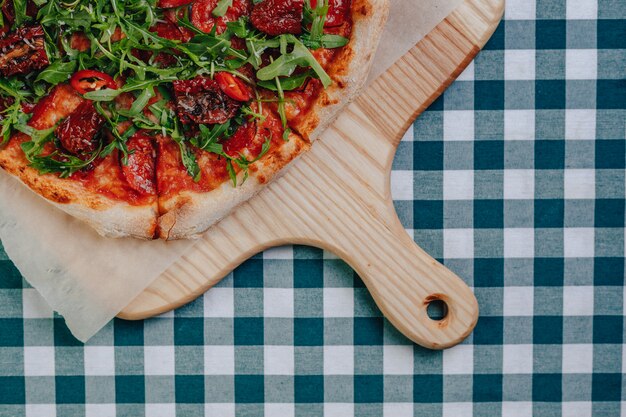 Pizza napolitana picante con jamón, queso, rúcula, albahaca, tomates, pimienta de pepperoni rociada con queso