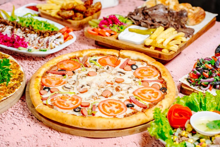 Foto gratuito pizza y otra comida en la mesa