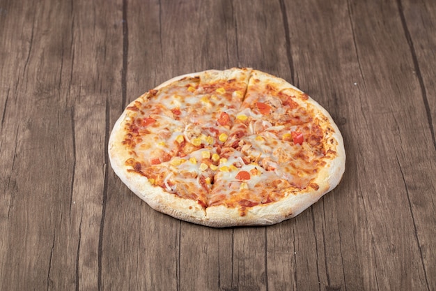 Pizza de pepperoni caliente en mesa de madera.