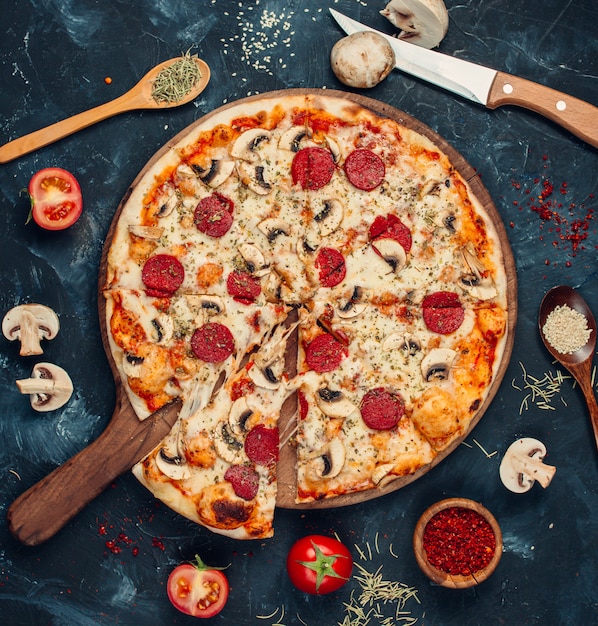 Pizza de pepperoni con champiñones sobre la mesa
