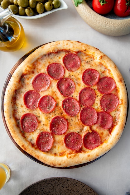 Pizza de pepperoni con hierbas encima