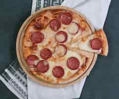 Foto gratuita pizza de pepperoni con queso blanco derretido en la parte superior.