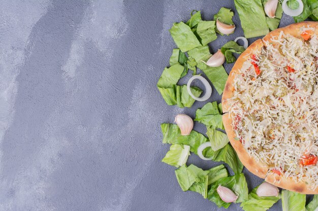 Pizza de pollo con queso en azul con verduras frescas.