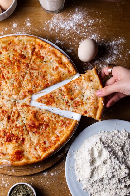 pizza de queso con especias en rodajas sobre la mesa de madera