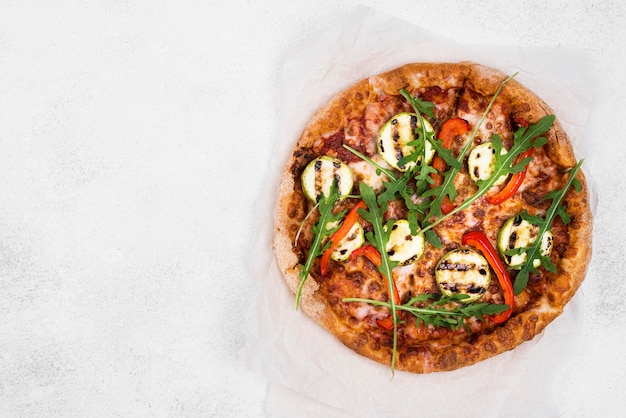 Pizza de rúcula con fondo blanco.