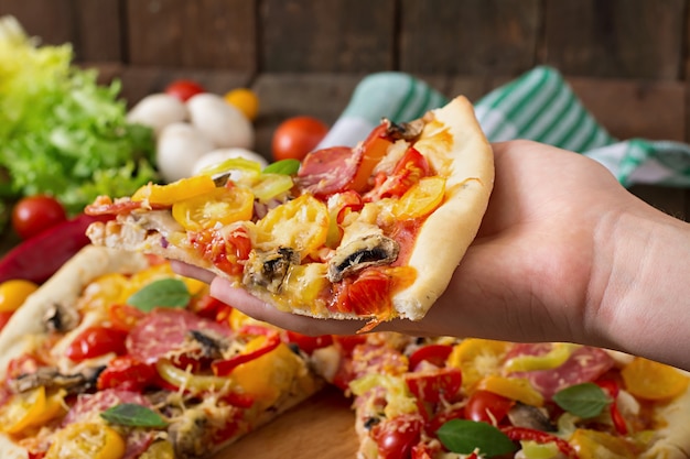 Pizza con salami, tomate, queso y champiñones.