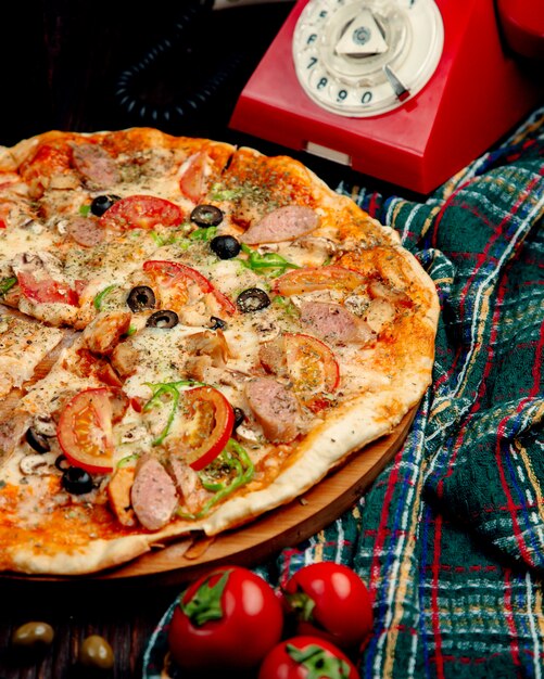 pizza con salchichas, tomate, pimiento dulce y aceitunas