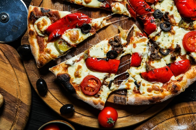 Pizza con salchichas, tomate, queso, aceitunas y pimiento