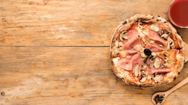 Pizza de tocino y champiñones al horno con salsa de tomate sobre una mesa de madera vieja