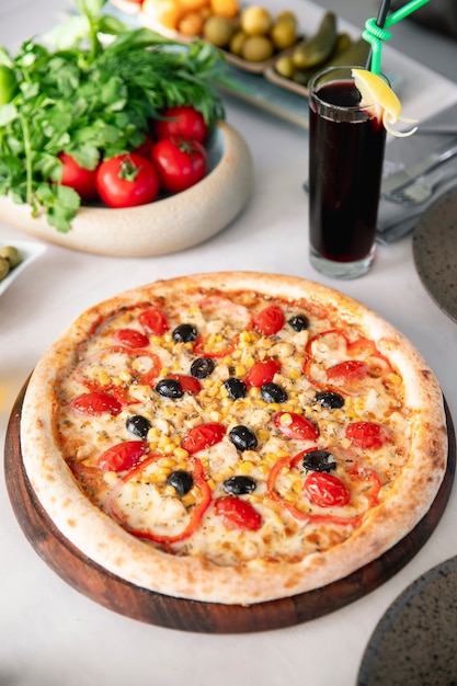 Pizza con tomates, aceitunas, maíz y pimientos