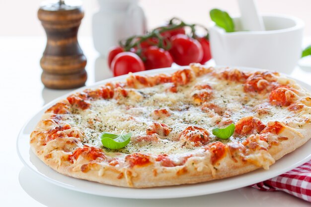 Pizza con tomates al lado