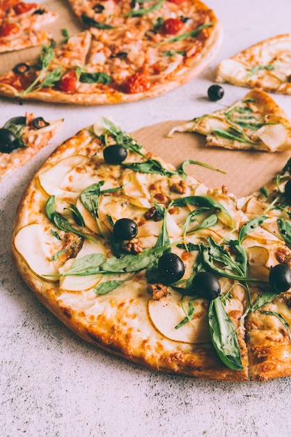 Pizzas cortadas sobre mesa blanca