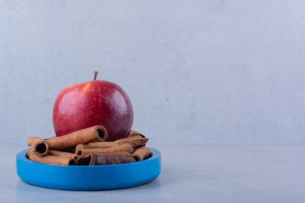 Foto gratuita placa azul llena de canela y manzana en la mesa de piedra.