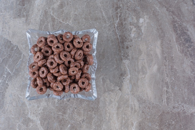 Una placa de cristal de anillos de cereales saludables de chocolate para el desayuno.