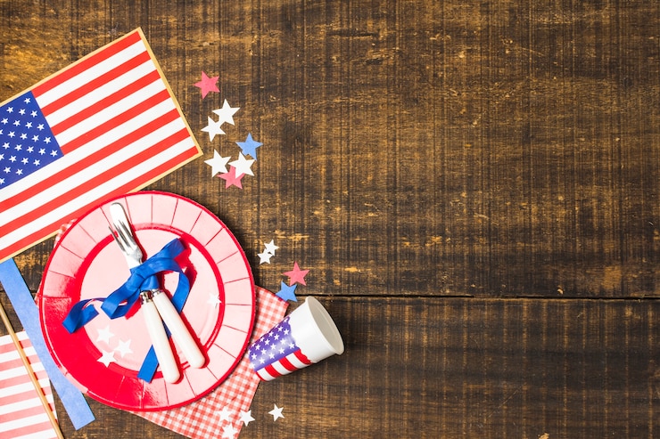 Foto gratuito placa y cubiertos de la bandera de los estados unidos atados con cinta azul con la bandera; vaso estrella y descartable en mesa de madera.