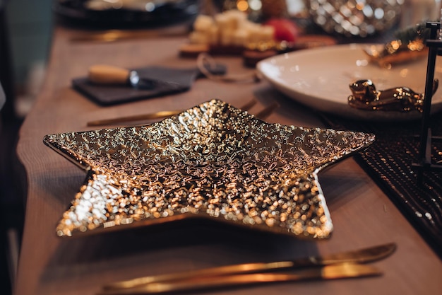 Placa dorada en forma de estrella en la mesa de Año Nuevo. Concepto de víspera de año nuevo