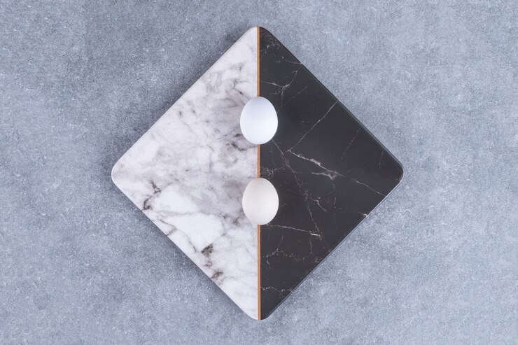 Foto gratuito placa de dos colores de huevos frescos crudos en piedra.
