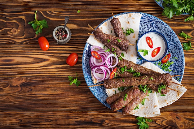 Placa de kebab de mezcla de Ramadán tradicional turco y árabe. Kebab adana, pollo, cordero y ternera sobre pan lavash con salsa. Vista superior