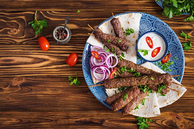 Placa de kebab de mezcla de Ramadán tradicional turco y árabe. Kebab adana, pollo, cordero y ternera sobre pan lavash con salsa. Vista superior