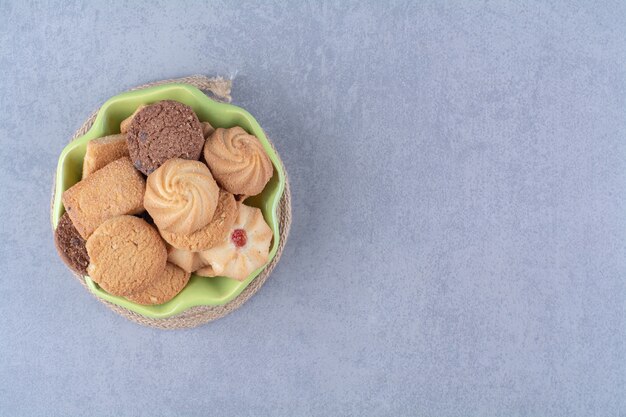 Una placa verde con dulces deliciosas galletas redondas de cilicio.