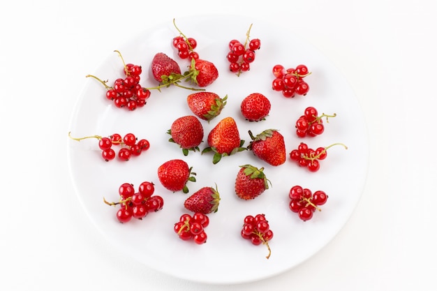 Placa de vista superior con fresas frescas y suaves sobre el fondo blanco color baya de fruta fresca suave