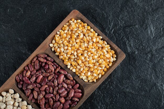 Placas de madera con frijoles crudos y palomitas de maíz en negro.