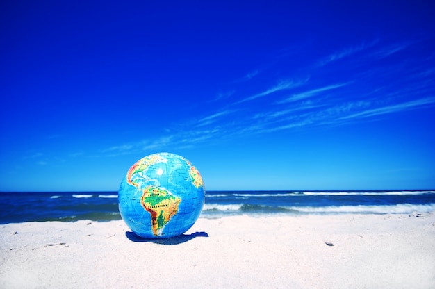 Planeta tierra en la playa de arena