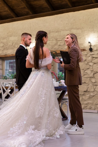 Foto gratuita planificador de bodas femenino que trabaja con la novia y el novio