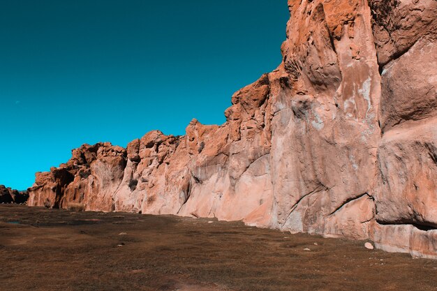 Plano amplio de acantilados rodeados de tierra con un cielo azul en un día soleado