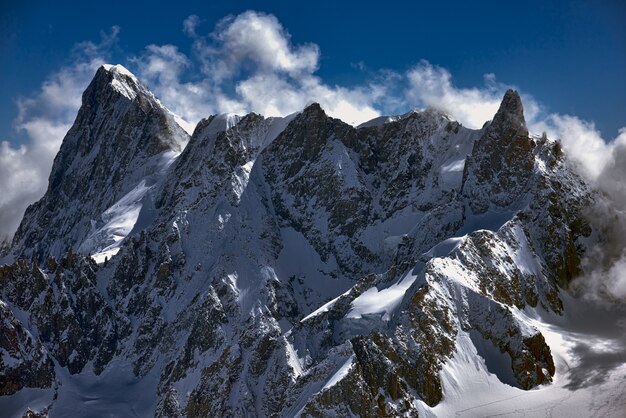 Plano amplio de un enorme pico de montaña completamente cubierto de nieve en una vista verdaderamente impresionante