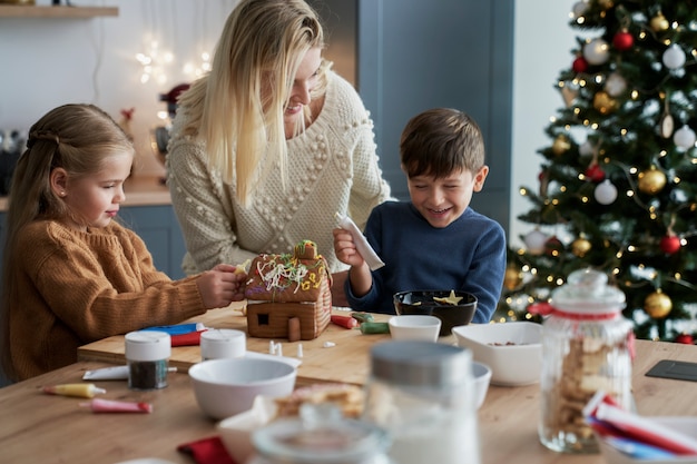 Plano amplio de familia pasar tiempo de Navidad horneando