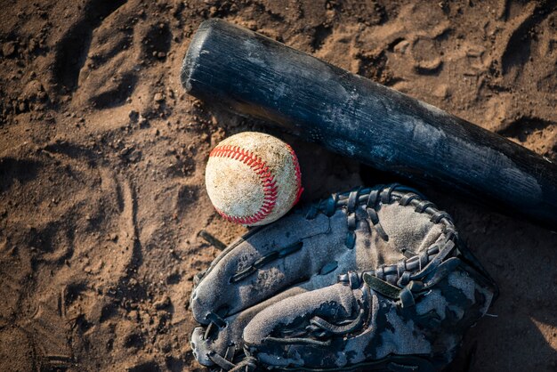 Plano de béisbol y bate en tierra