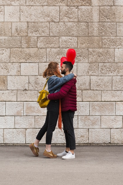 Plano completo de la feliz pareja abrazándose