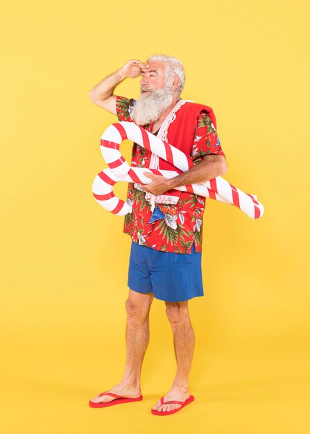 Plano completo de hombre con camisa tropical y sombrero de navidad