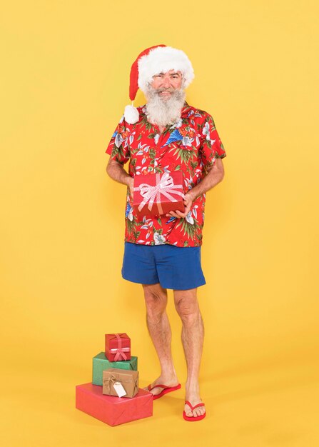 Plano completo de hombre con camisa tropical y sombrero de navidad