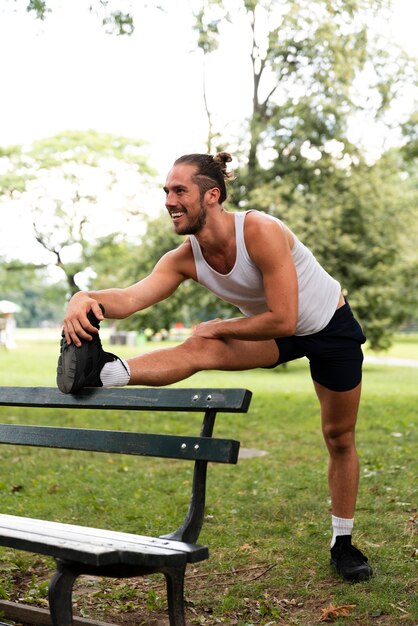 Plano completo del hombre estirando en el parque