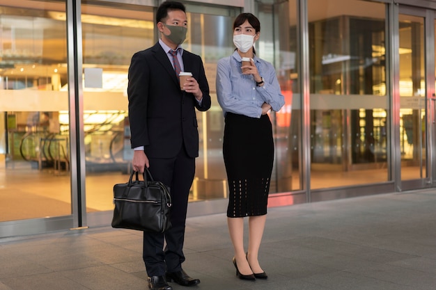 Foto gratuita plano completo de hombre y mujer con mascarilla