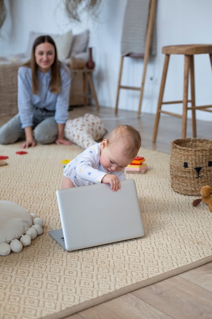 Plano completo madre y bebé con laptop