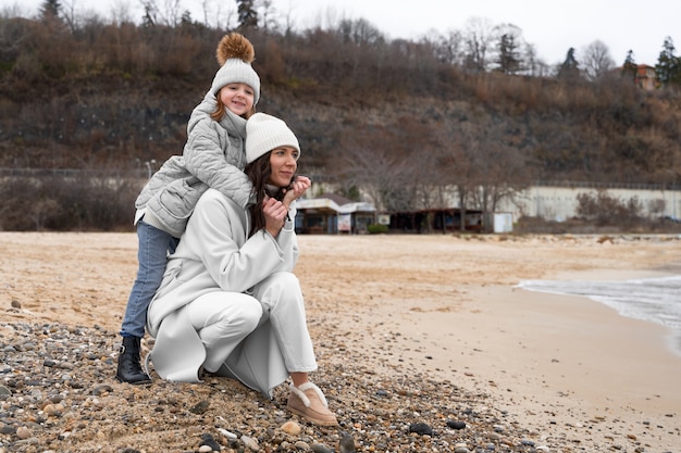 Foto gratuita plano completo madre e hijo en la playa