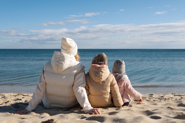 Plano completo madre e hijos en la playa