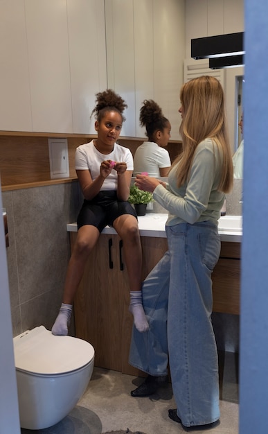 Plano completo madre y niña en el baño.