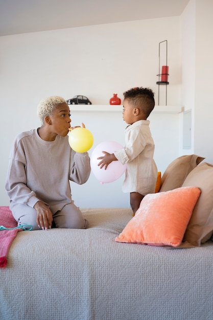 Foto gratuita plano completo madre y niño con globos.