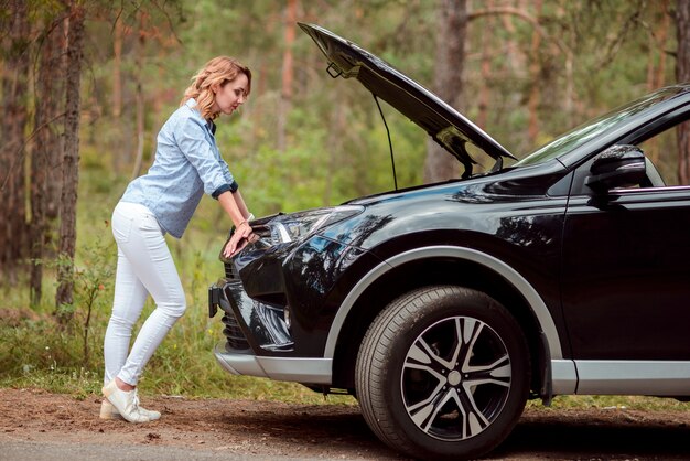 Plano completo de mujer comprobando coche