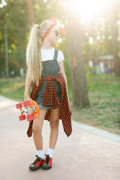 Plano completo de niña con patineta