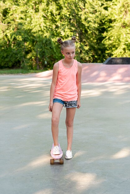 Plano completo de niña con patineta