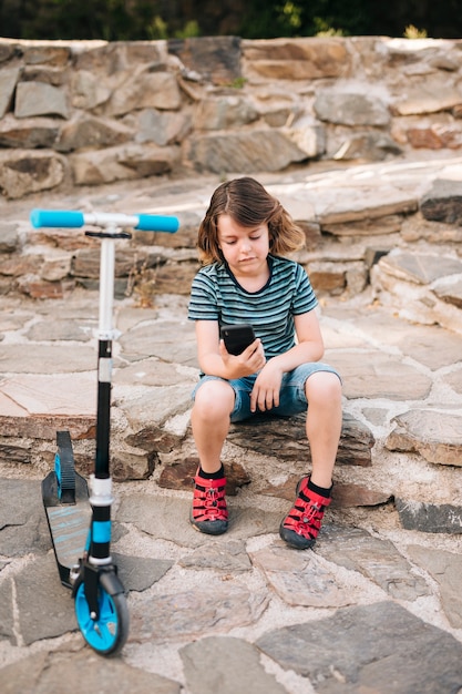 Plano completo del niño mirando el teléfono